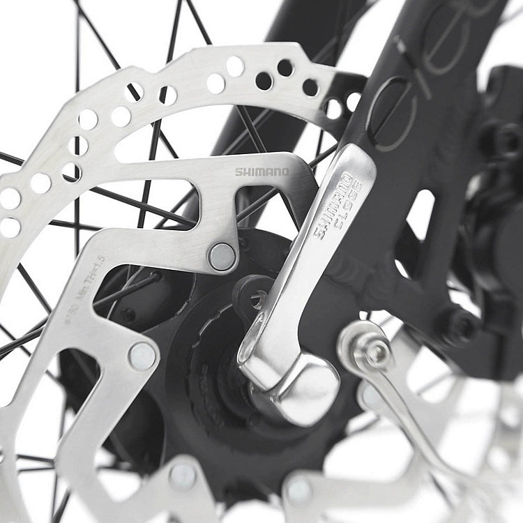 Close-up of a bicycle disc brake system with Shimano branding.