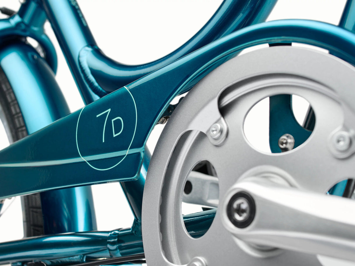 Close-up of a teal bicycle frame with '7D' branding on a white background