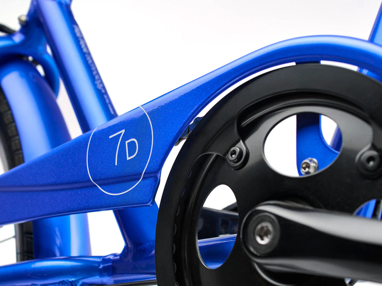 Close-up of a blue bicycle frame with a gear and chain on a white background