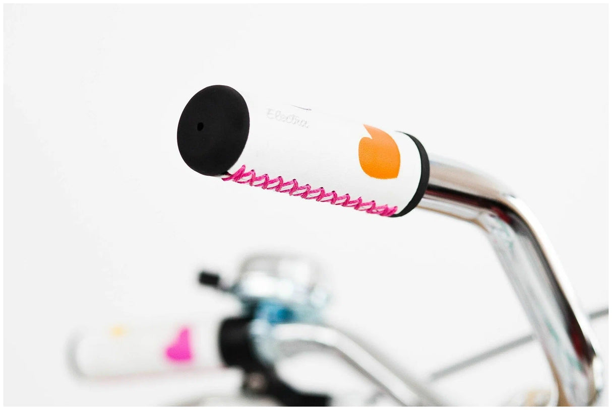 Close-up of a bicycle handlebar with a colorful bell on a white background