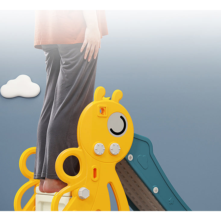 Child's feet standing on yellow honeybee-shaped steps with a blue slide in the background.