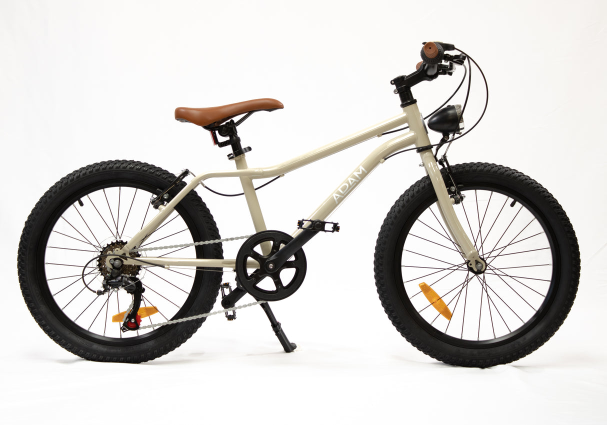 Beige children's bike with black tires on a white background