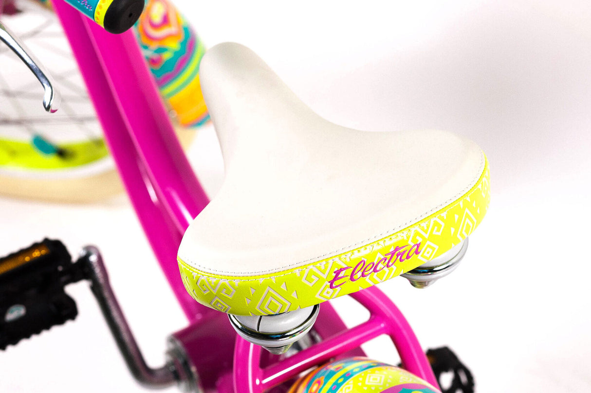 Close-up of a pink children's bike with a white seat and colorful frame on a white background.