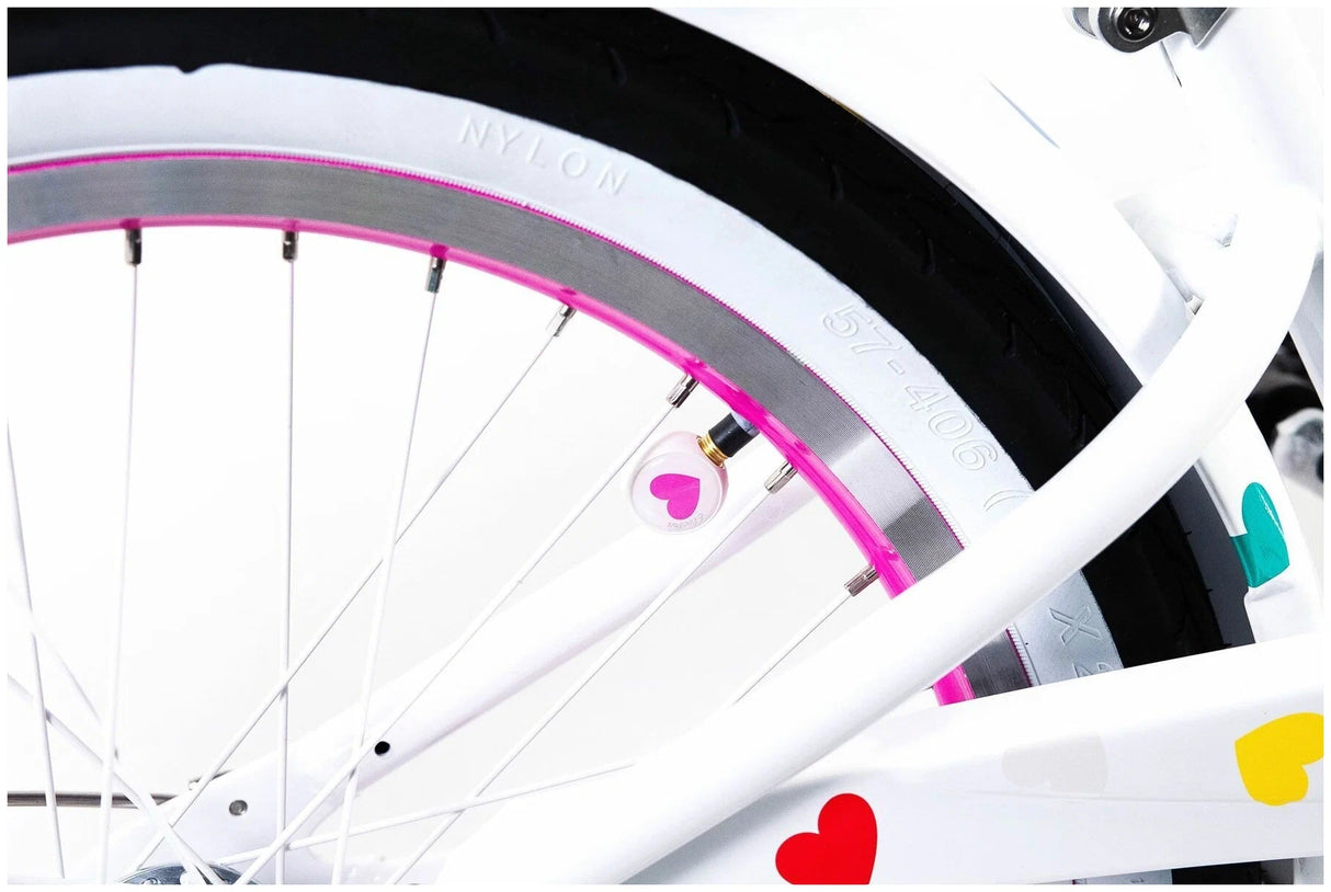 Close-up of a bicycle wheel with colorful heart designs on a white background