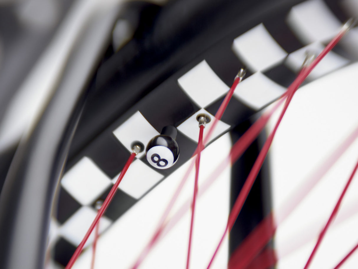 Close-up of a bicycle wheel with red spokes and a black rim featuring a logo.