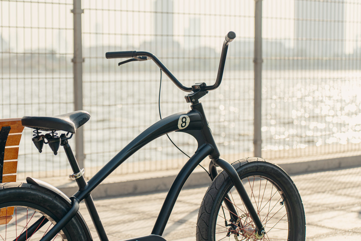 Black bicycle leaning against a fence with a blurred background