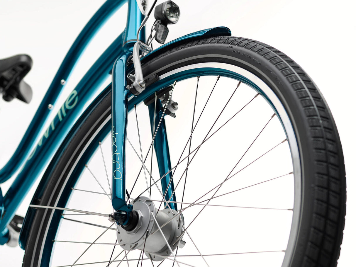 Close-up of a teal bicycle wheel with visible brand name on a white background