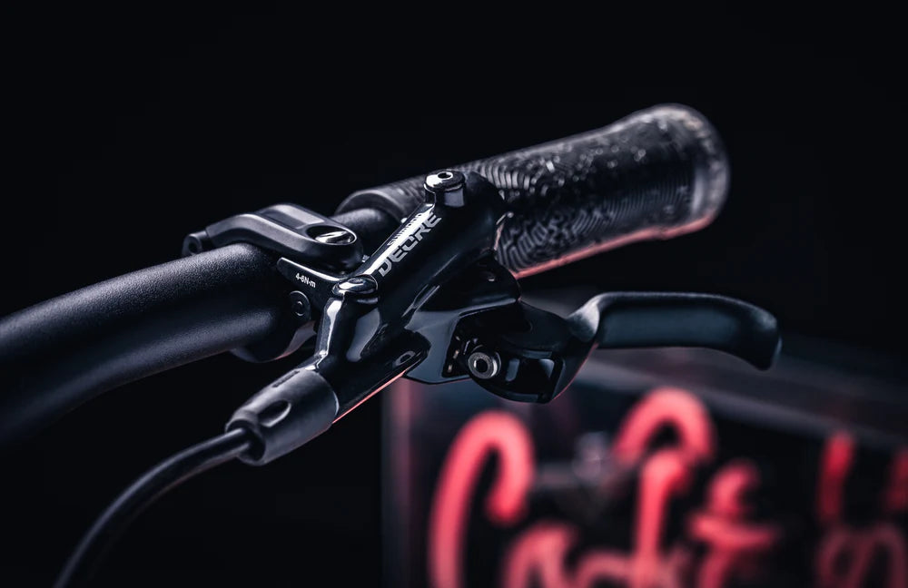 Close-up of a bicycle handlebar with a visible brand logo on a dark background