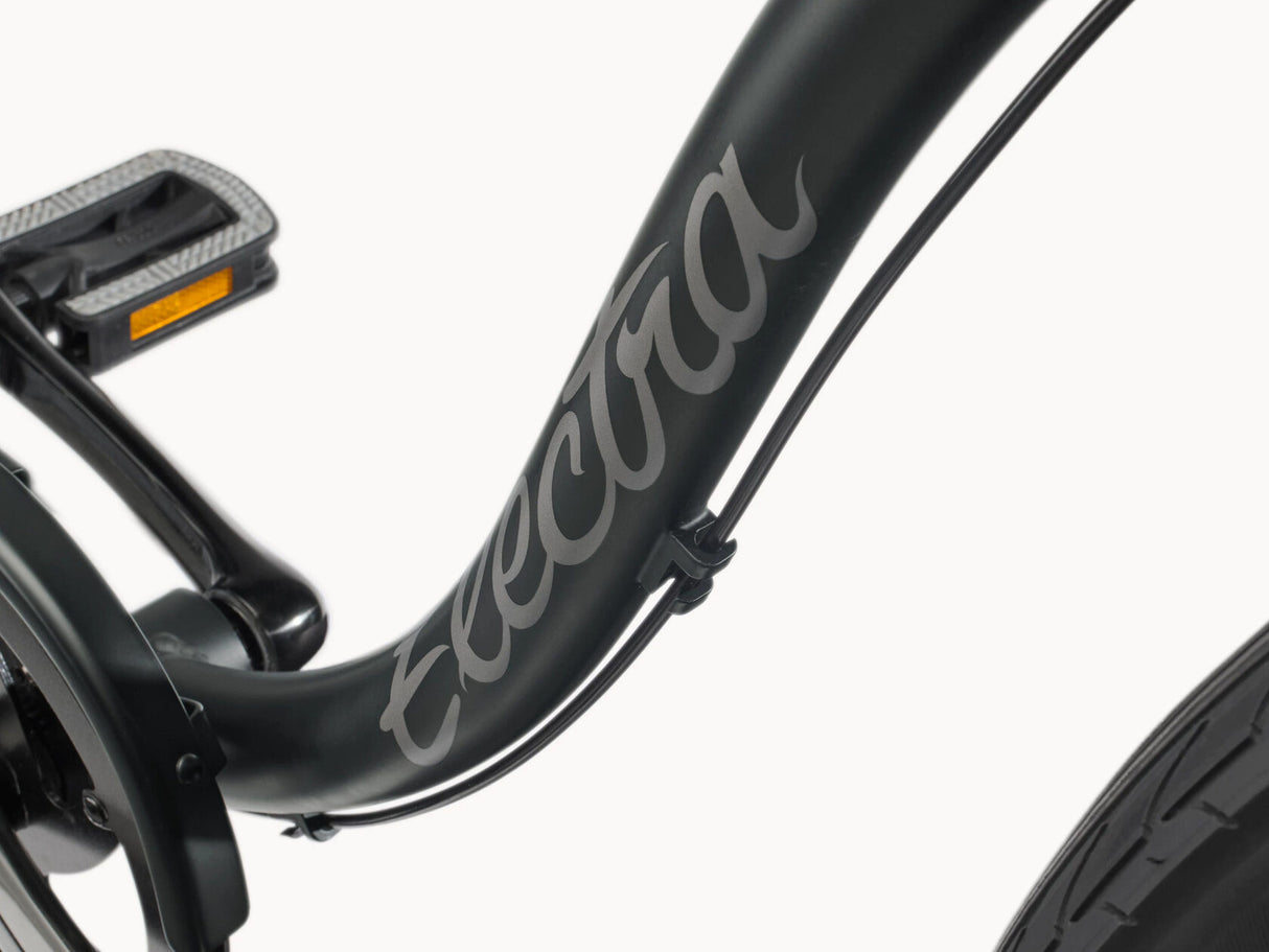 Close-up of a black electric bike frame with 'Electra' branding on a white background
