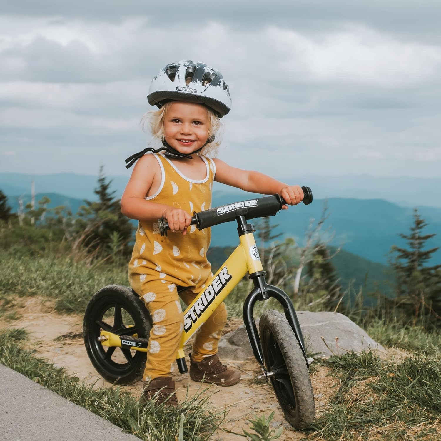 Child with a balance bike in a natural setting