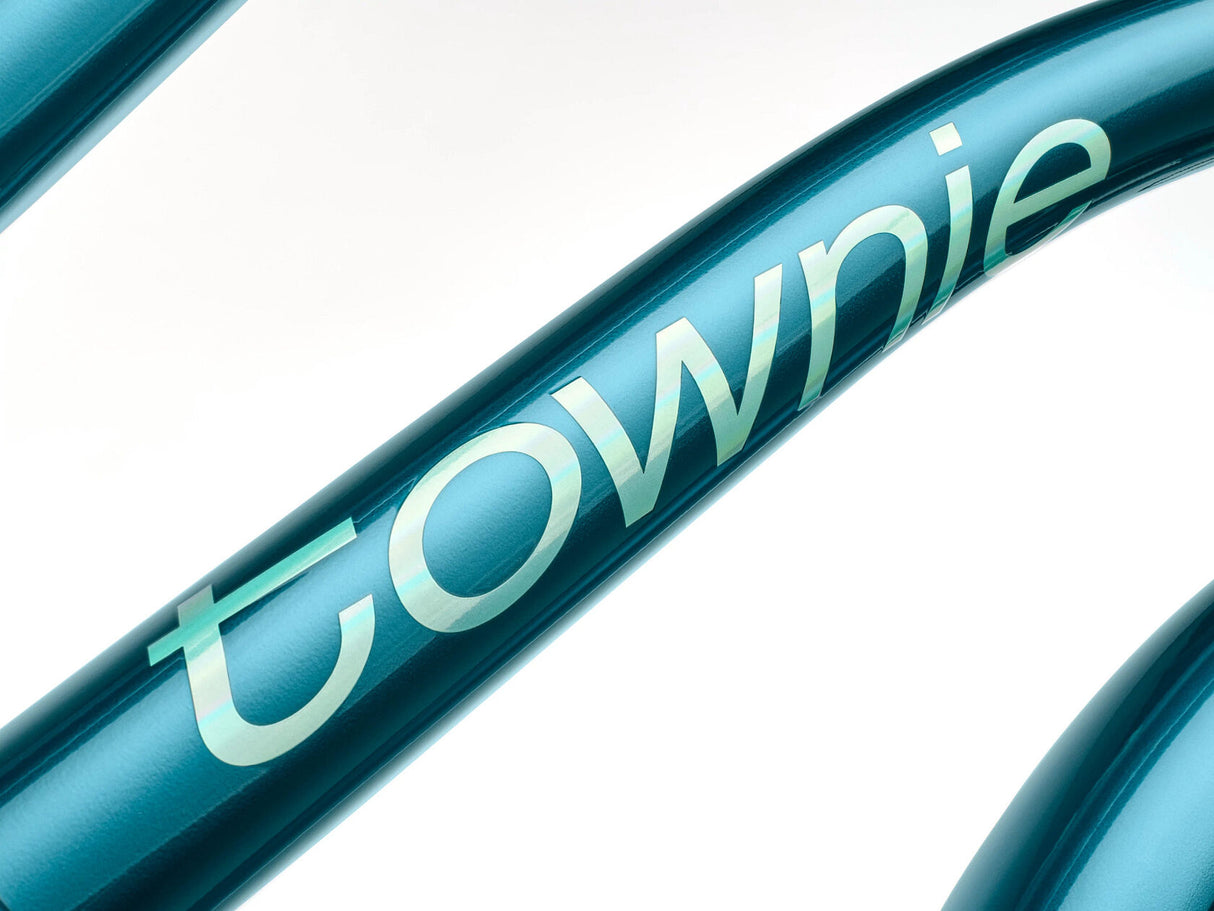 Close-up of a teal bicycle frame with 'townie' branding on a white background