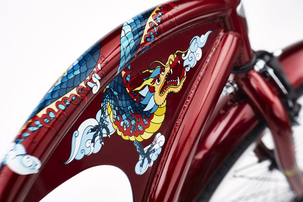 Close-up of a red bicycle frame with dragon and cloud design