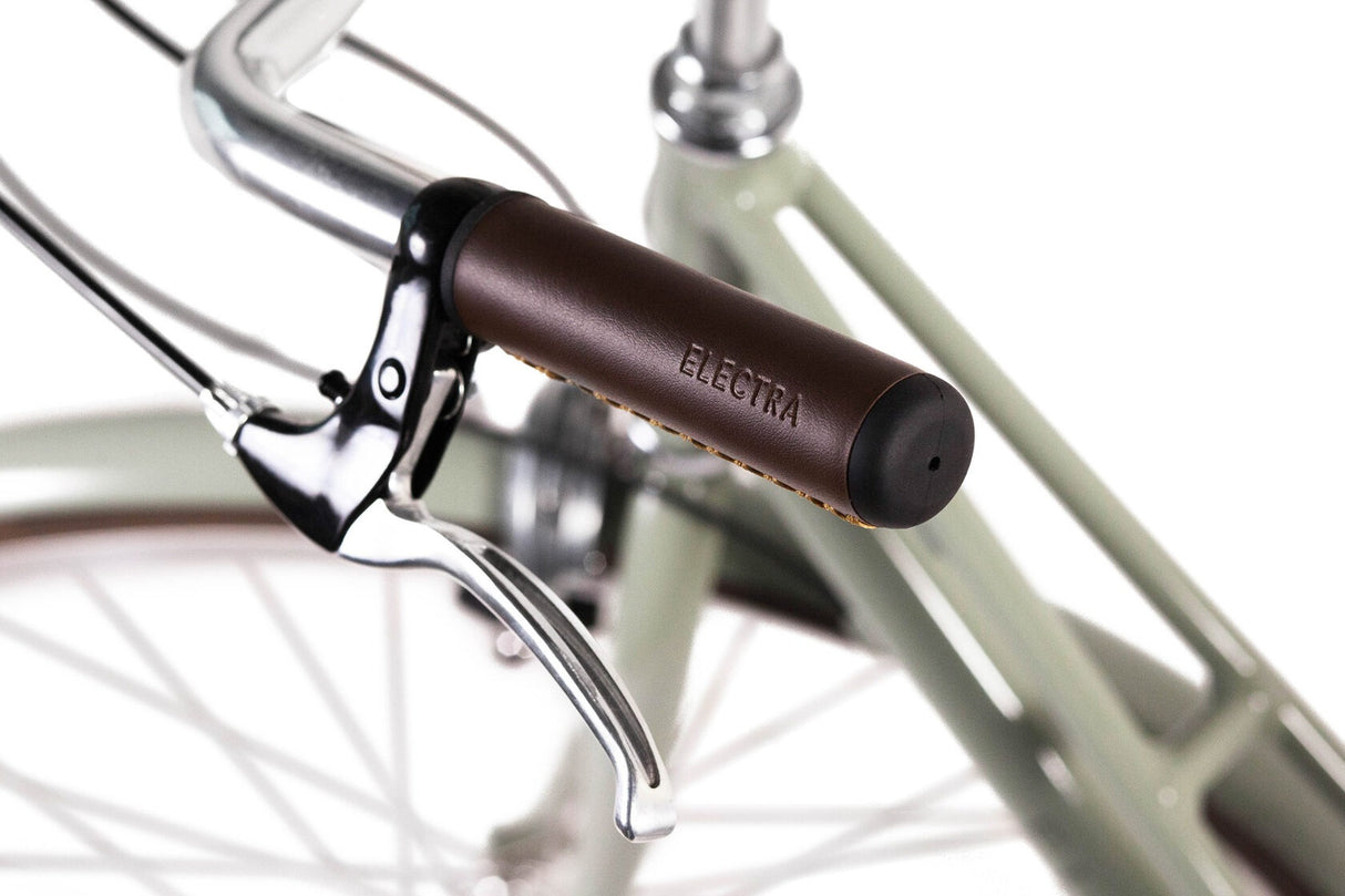 Close-up of a bicycle handlebar with brown grip and 'Electra' branding on a white background