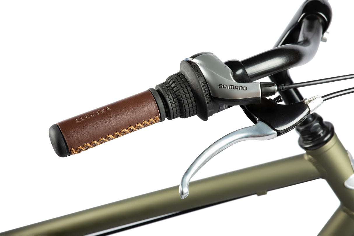 Close-up of a bicycle handlebar with brown grip and Shimano lever on a white background