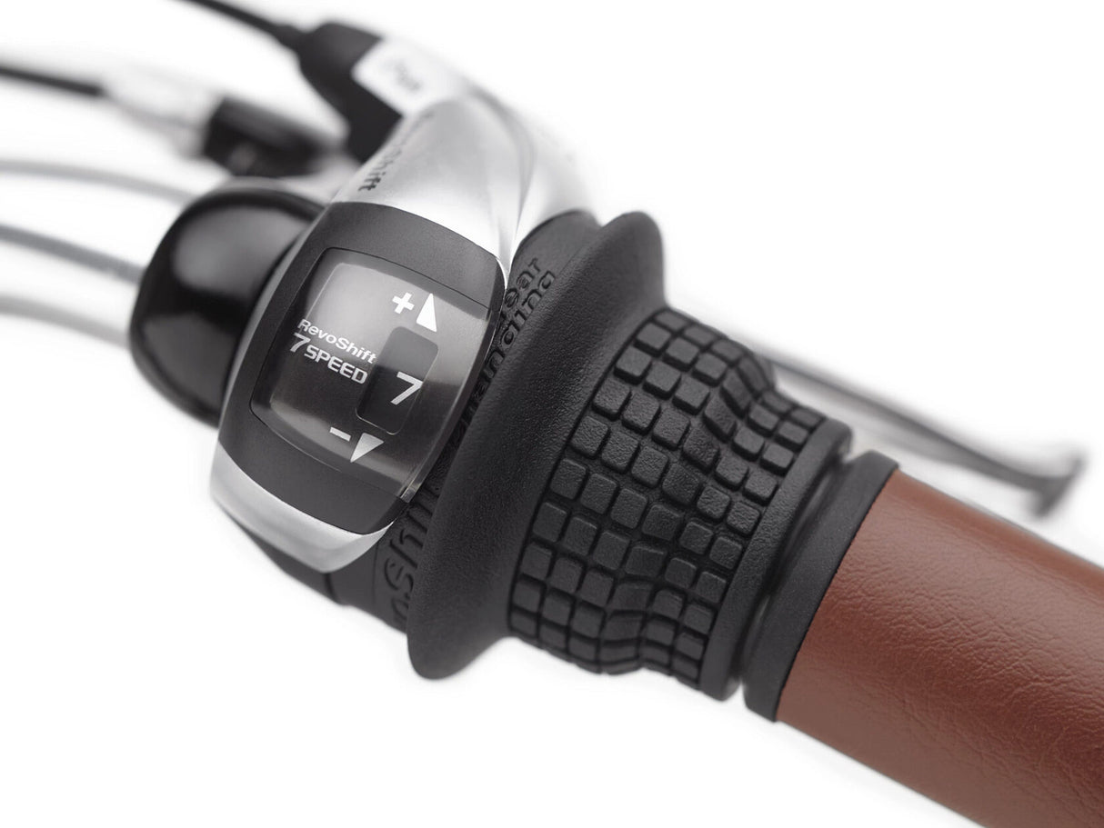 Close-up of a bicycle gear shifter with a brown handle on a white background