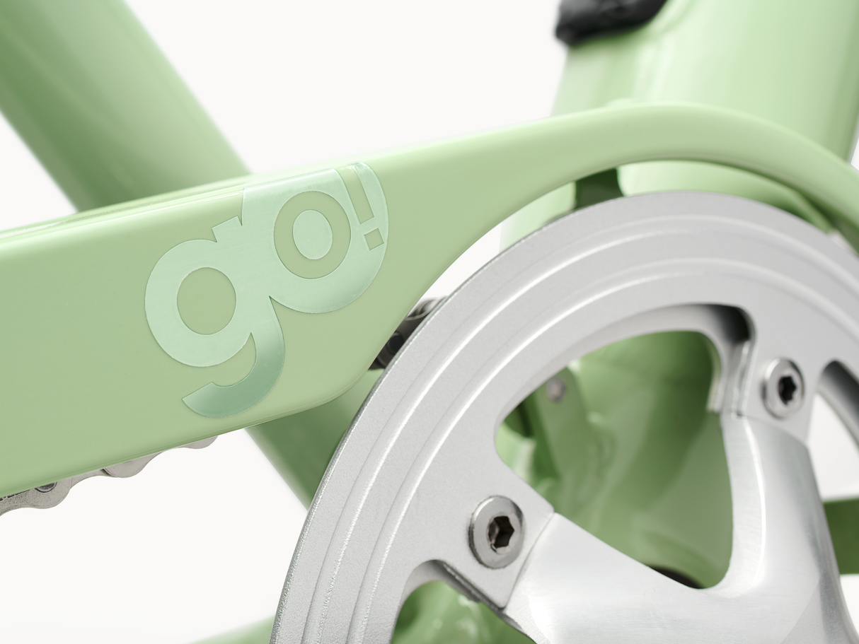 Close-up of a green bicycle frame with 'go!' branding and a silver chainring.