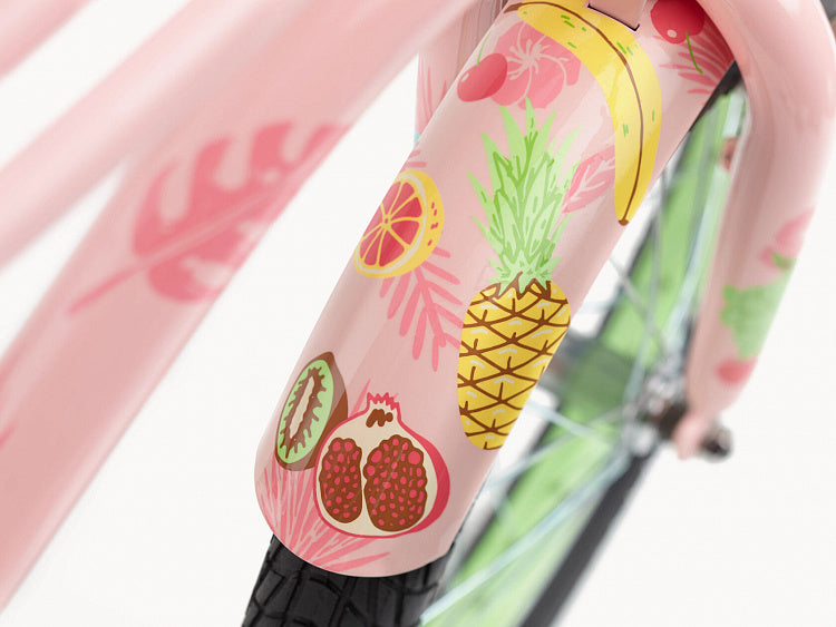 Close-up of a bicycle with pink frame and fruit-themed decal on a white background