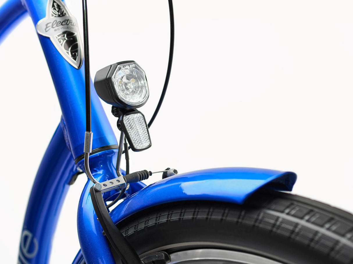 Close-up of a blue bicycle with a front light on a white background