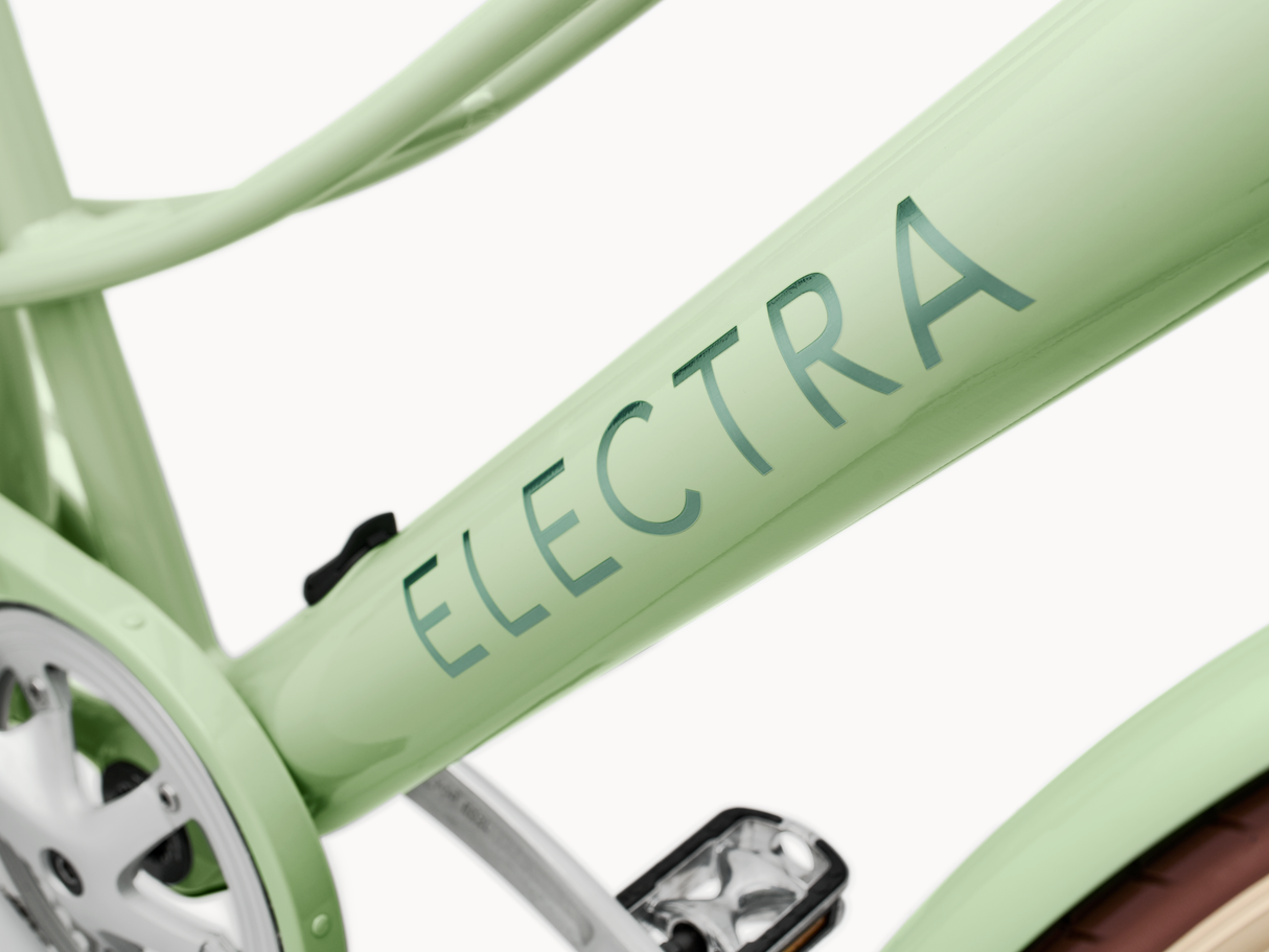 Close-up of a light green Electra bicycle frame with 'Electra' branding.