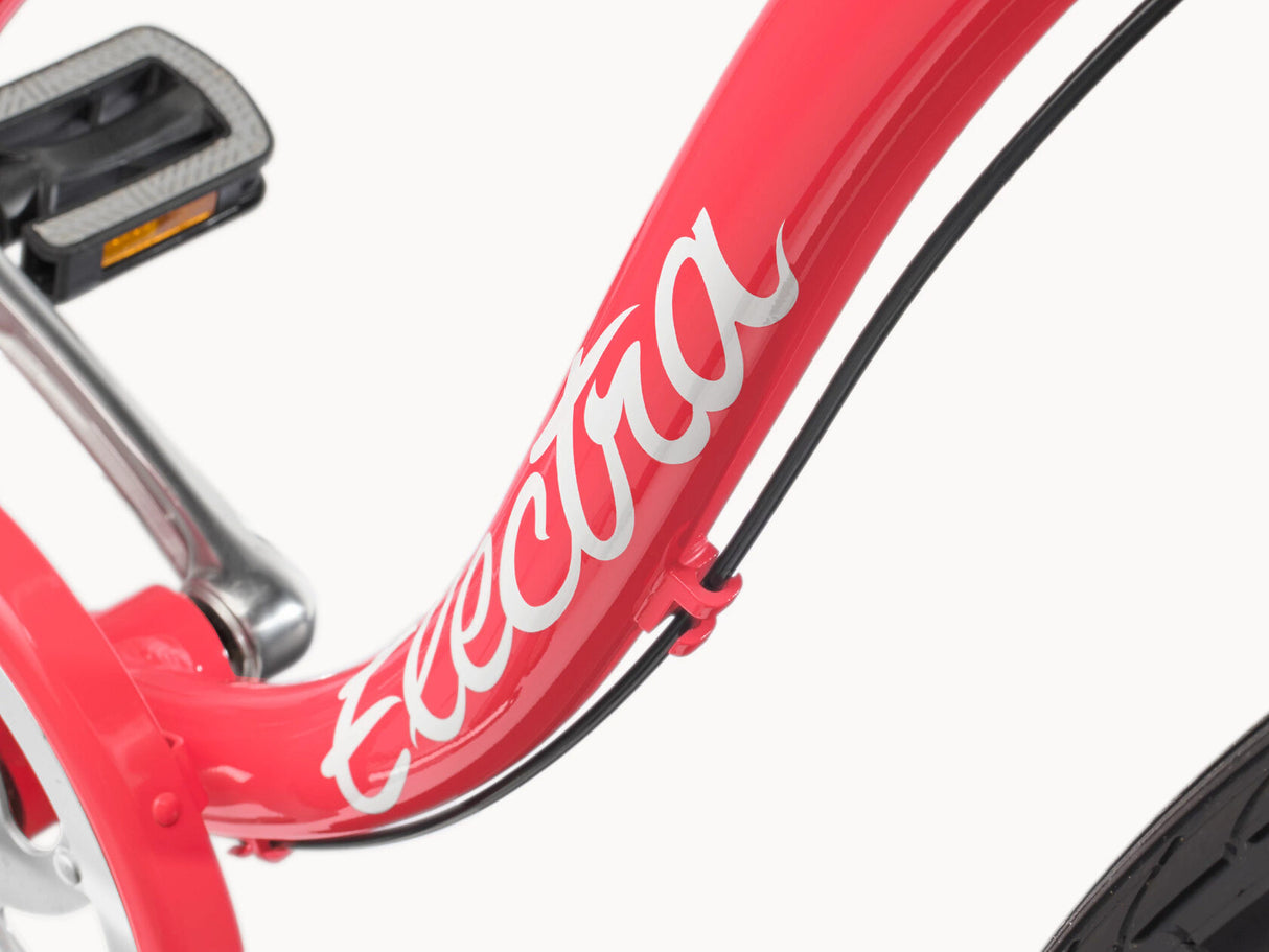 Close-up of a red bicycle frame with 'Electra' branding on a white background