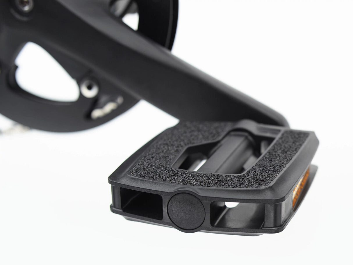 Close-up of a black bicycle pedal on a white background