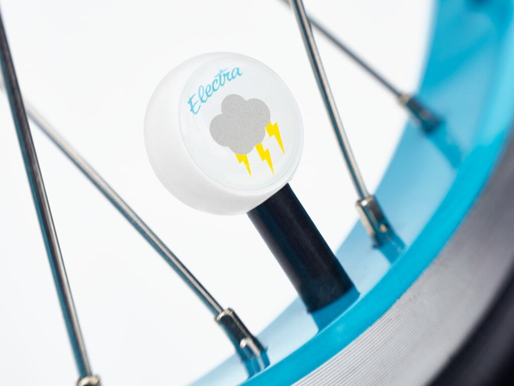 Close-up of a bicycle wheel with a white ball featuring 'Electra' branding and a cloud with lightning symbol.