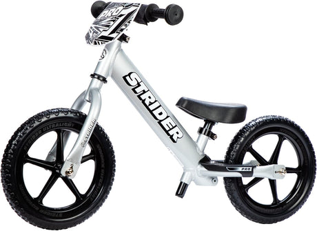 White Strider balance bike with black wheels on a white background