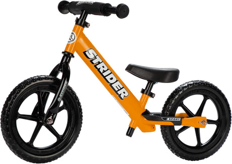 Orange balance bike with black wheels on a white background