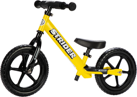 Yellow balance bike with black seat and wheels on a white background
