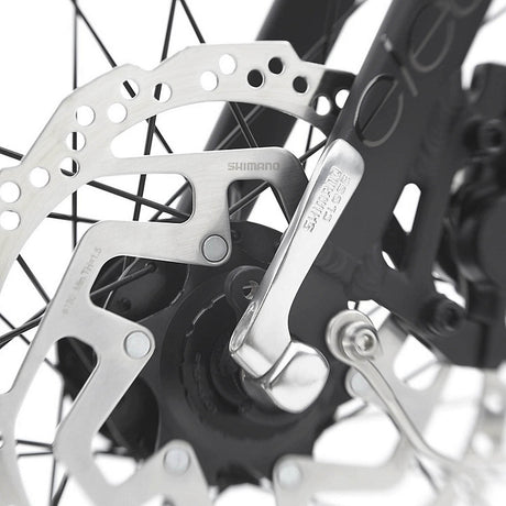Close-up of a bicycle disc brake system with Shimano branding.