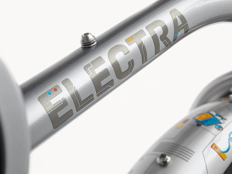 Close-up of a silver Electra bicycle frame with branding.