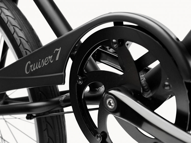 Close-up of a bicycle chain and gear system with 'Cruiser 7' branding on a white background.