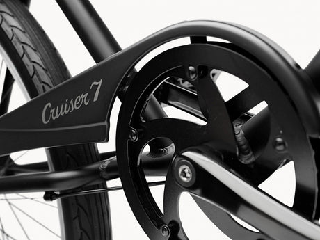 Close-up of a bicycle chain and gear system with 'Cruiser 7' branding on a white background.