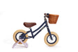 Navy balance bike with a brown basket on a white background