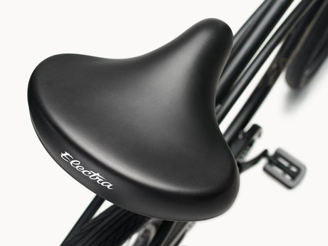 Black bicycle seat with 'Electra' branding on a white background