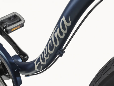 Close-up of a navy blue bicycle frame with 'Electra' branding on a white background