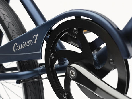 Close-up of a bicycle chain and gear system with 'Cruiser 7' branding.