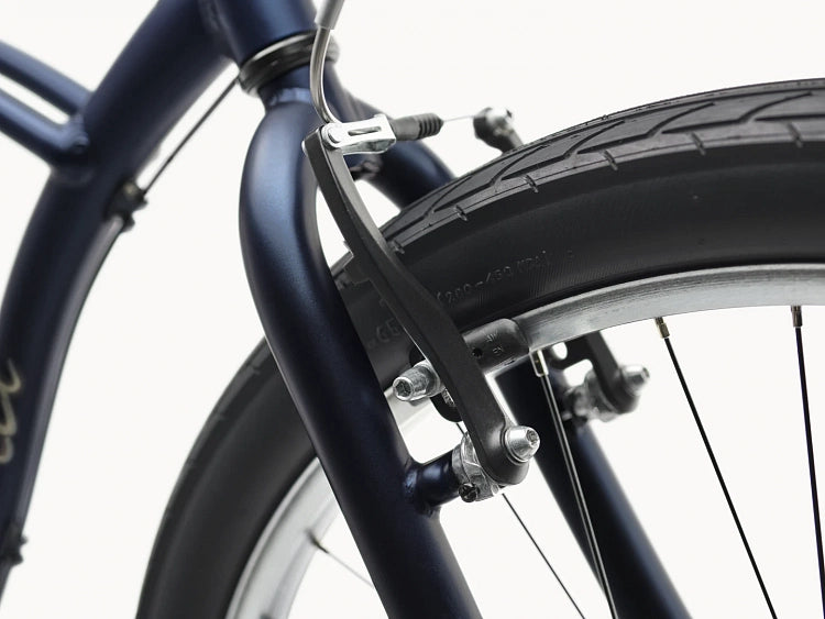 Close-up of a bicycle's front wheel and suspension fork on a white background