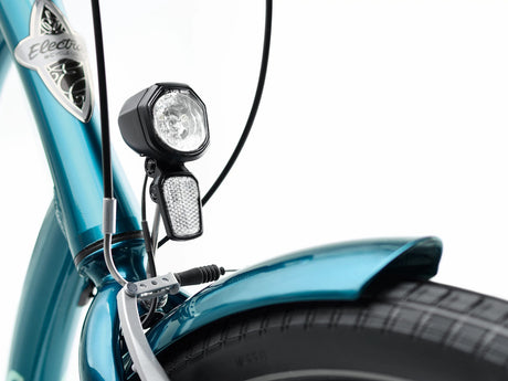 Close-up of a blue bike with headlight and handlebar controls on a white background