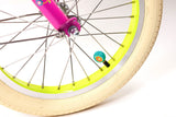 Close-up of a bicycle wheel with a pink rim and yellow rim tape on a white background