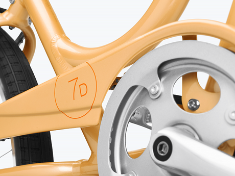 Close-up of a bicycle frame with a gear and '7D' branding on a white background