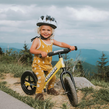 Child with a balance bike in a natural setting