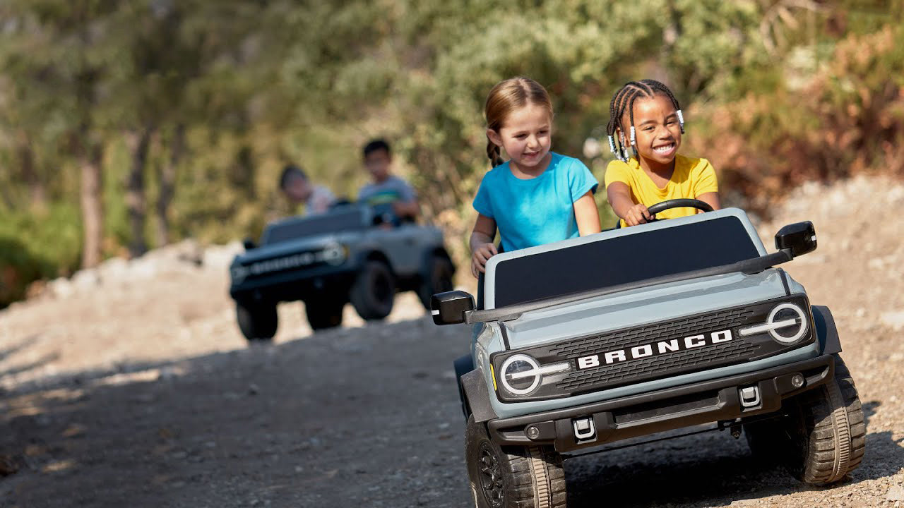 Children playing with toy cars on a dirt road